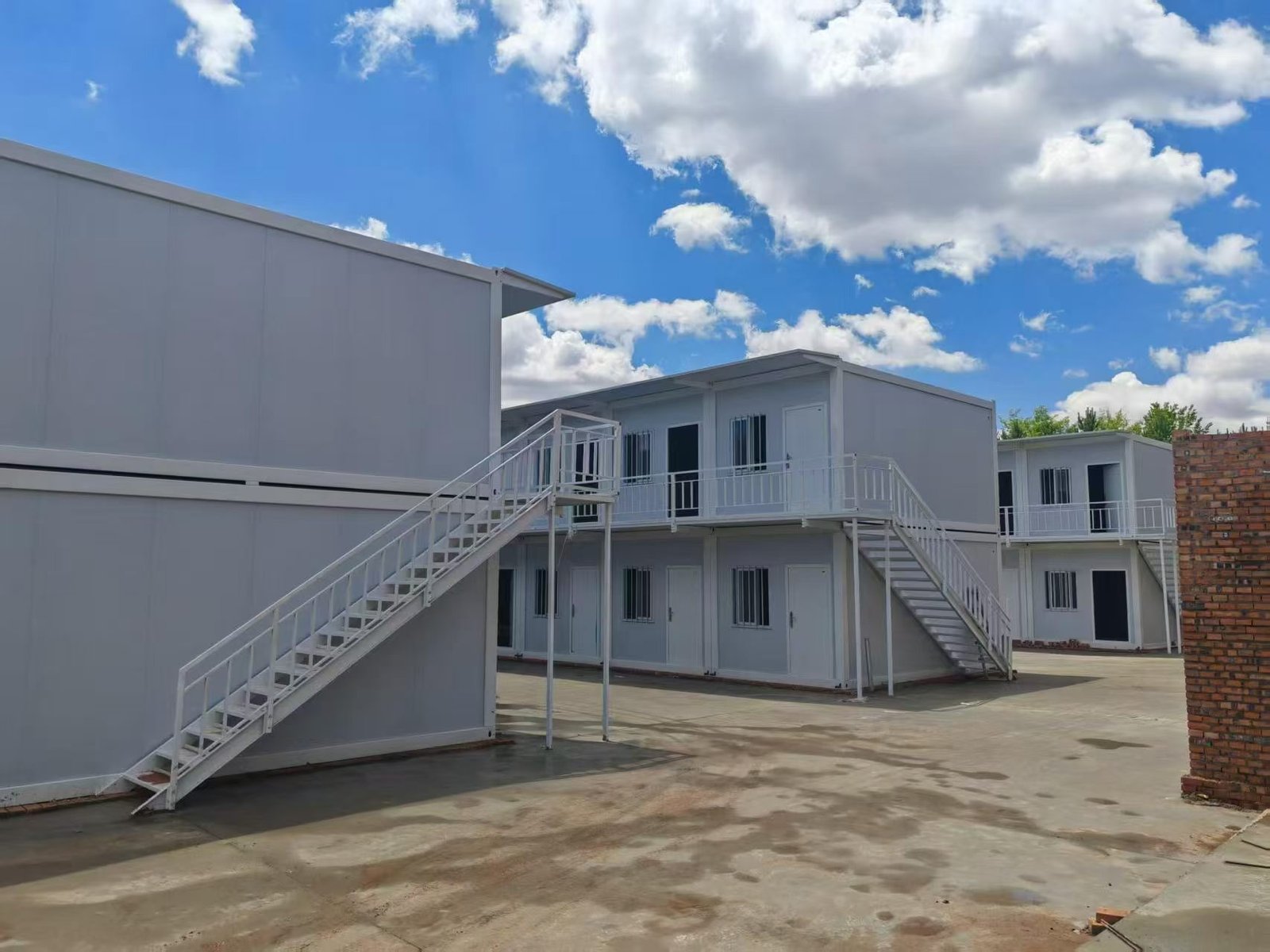 Two-storey modular container units connected by exterior stairs and balconies