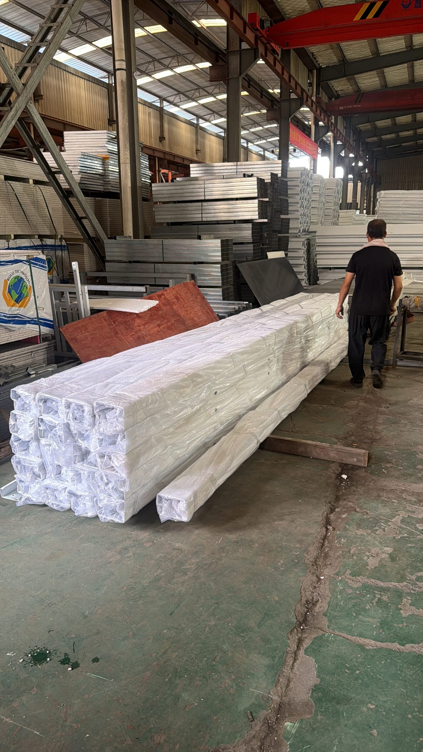 Wrapped steel frame components for flat pack container houses prepared for shipment in the factory
