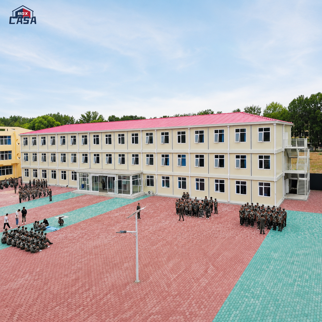 Three-storey modular school building with a red pitched roof and courtyard